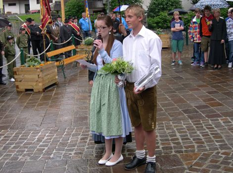 Ines Huber und Rudolf Mayrhofer (Firmlinge) im Hintergrund einige der ausgerückten Vereine (FFW, Kameraden, USV) und Firmlinge